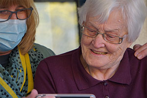 Carer helps an elderly woman